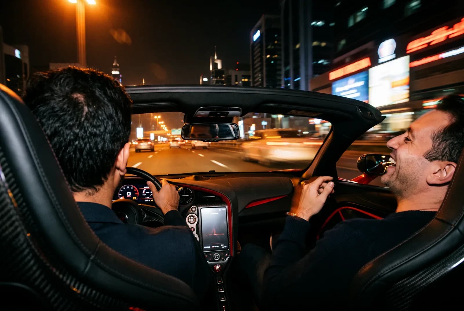 Two members mid-conversation on a night drive through Dubai